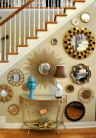 Superior Design:
This staircase wall went from boring to brassy with a bold collection of metallic mirrors. Angel also created a unique focal point by framing the center mirror with a side table, lamp, and turquoise vase.                                        